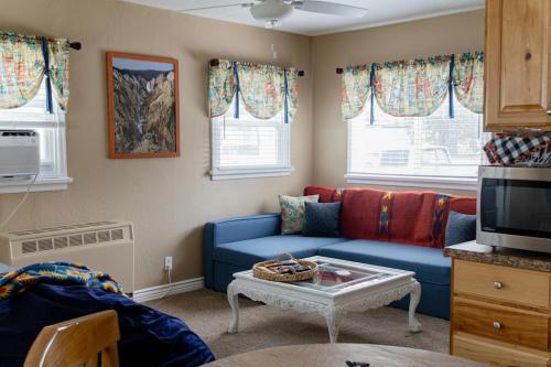 a living room with a blue couch and a table at Our Little Yellow House in Saint Anthony