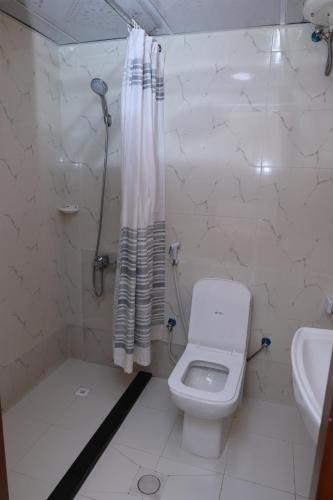 a bathroom with a toilet and a shower and a sink at Al Khaima Hotel in Dubai