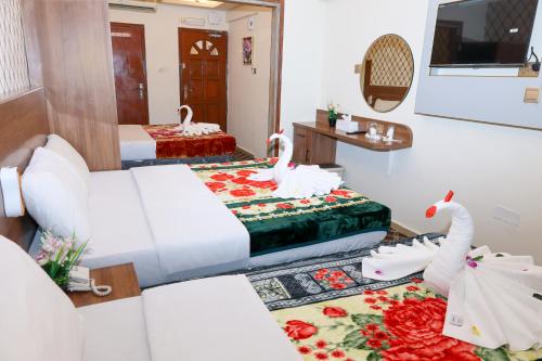 a hotel room with two beds and swans on the floor at Al Khaima Hotel in Dubai