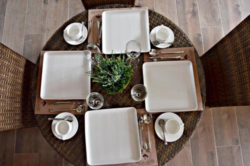 a table with white plates and silver utensils on it at The Piccolo Hotel of Boracay in Boracay