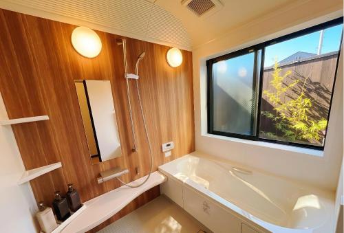 a bathroom with a large window and a white tub at 桃夭庵 touyouan momo house kujo 一棟貸切 in Kyoto