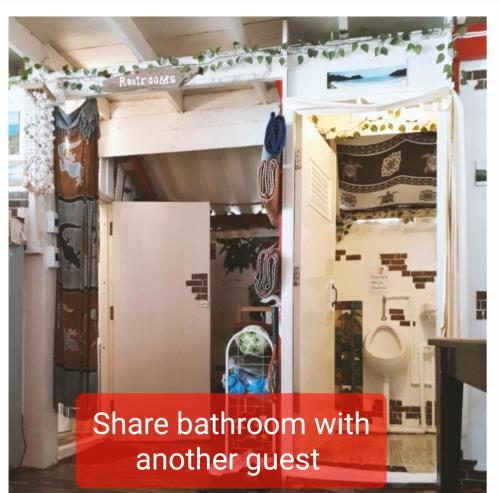 a small room with a bathroom with another guest at ThaiMex Cafe & Homestay Backpackers- Adults Only in Prachuap Khiri Khan