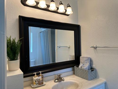 a bathroom sink with a large mirror above it at Suite A with a kitchen in Sacramento