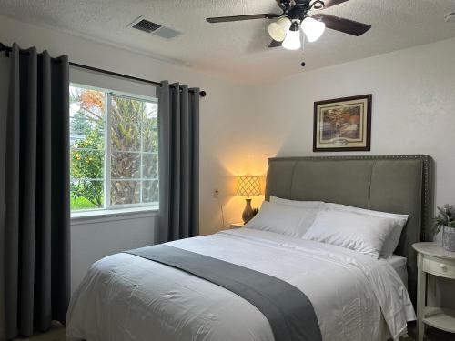 a bedroom with a bed with a ceiling fan and a window at Suite A with a kitchen in Sacramento