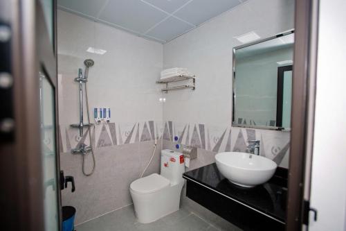 a bathroom with a sink and a toilet and a mirror at King House Hotel in Móng Cái