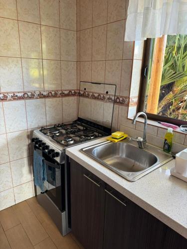 a kitchen with a stove and a sink at Cabañas Anavai Rapa Nui in Hanga Roa