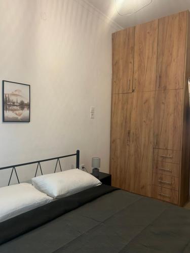 a bedroom with two beds and a wooden closet at MINAS CENTRAL apartments in Heraklio