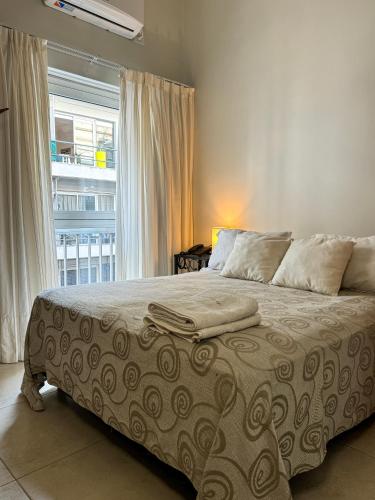 a bed in a bedroom with a large window at Hotel Europa in Buenos Aires