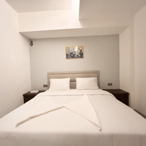 a large white bed with two pillows on it at Almasar Hotel in Maţār as Sīb ad Duwalī