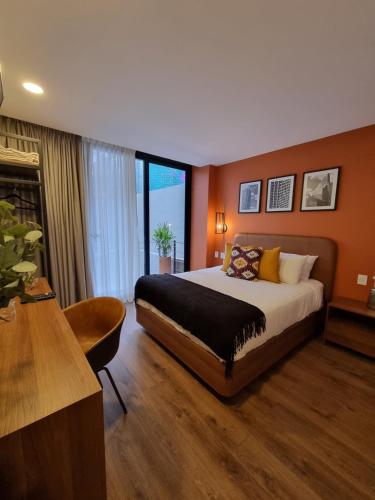 a bedroom with a large bed in a room with orange walls at Condesa Cibel in Mexico City