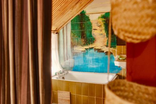 a bathroom with a bath tub and a window at Le Karthala in Antananarivo