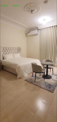 a bedroom with a bed and a chair and a table at شقق قاردينيا in Aş Şafā
