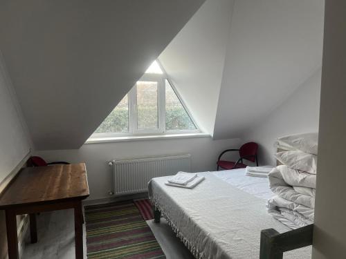 a bedroom with a bed and a table and a window at Hanul lui Hanganu in Lalova