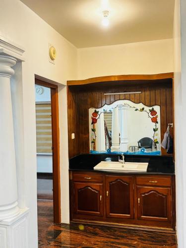 a bathroom with a sink and a mirror at Gem Palace in Perumpāvūr