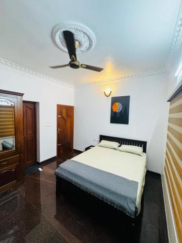 a bedroom with a bed and a ceiling fan at Gem Palace in Perumpāvūr