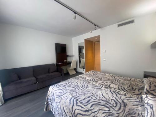 a bedroom with a zebra print bed and a couch at Hotel 9 Sant Antoni Only Adults in Ribes de Freser