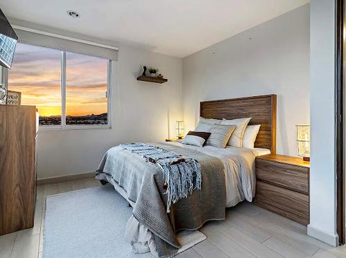 a bedroom with a large bed and a window at Depa Penthouse en Juriquilla con terraza y alberca climatizada in Juriquilla