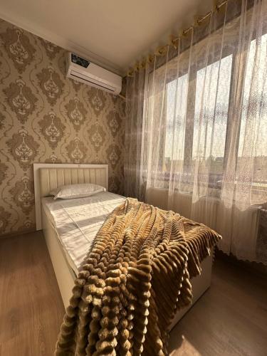 a bedroom with a bed and a window at Welcome home apartments in Samarkand