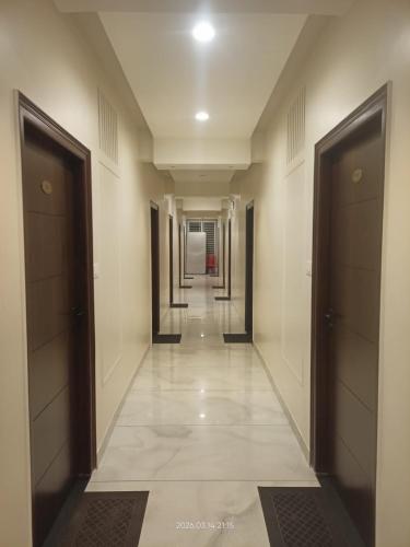 a hallway of a building with doors and tile floors at The Nature Park Hotel in Mudhol