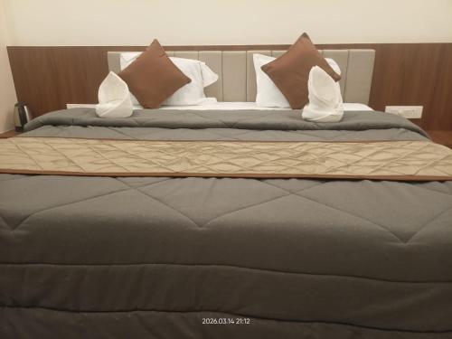 a large bed with pillows on top of it at The Nature Park Hotel in Mudhol