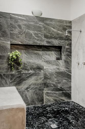 a bathroom with a black marble wall at CASA EN EL CENTRO & CORAZON DE CANCUN in Cancún