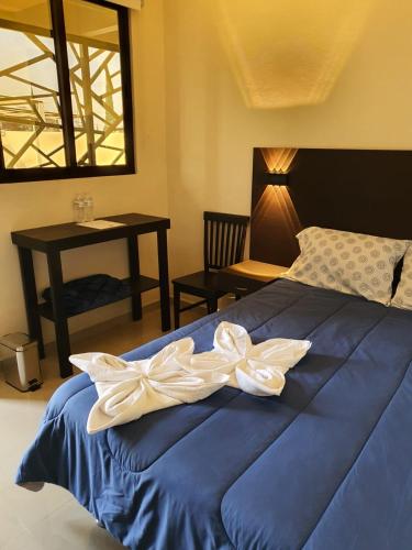 a bedroom with a blue bed with a white bow on it at Hotel y Motel Elegantia in Tetelco