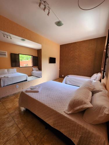 a large bedroom with two beds and a window at Espaço Sunshine in Saquarema