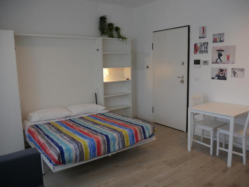 a small bedroom with a bed and a table at Guest House Il Colibri' in Bologna