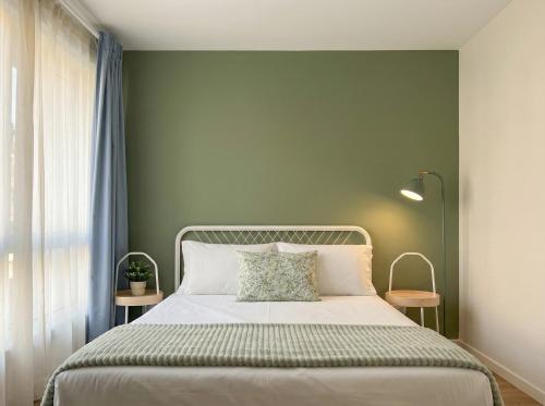 a bedroom with a bed with a green wall at Magnolia Suites & Stays in Porto