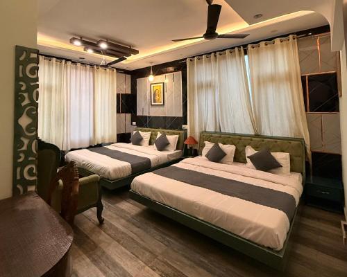 a hotel room with two beds and a couch at Pacific Grand in Amritsar