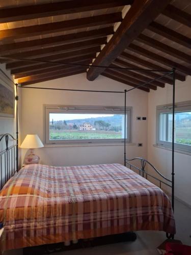 a bedroom with a bed and a large window at Casa Al Vento in Lucignano