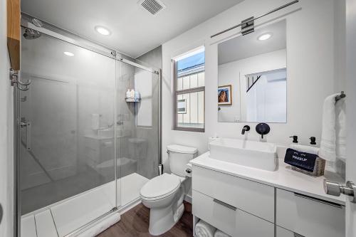 a white bathroom with a shower and a toilet at The Riv at Zion in Virgin