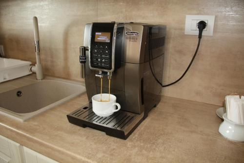 a coffee machine on a counter with a cup in it at Central Dorgali Guest House in Dorgali