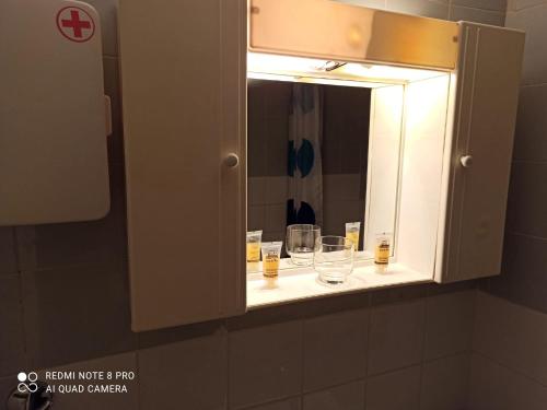 a medicine cabinet with glasses on a shelf in a bathroom at Rooms To Let Giannis in Makrygialos