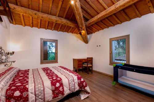 a bedroom with a bed and a wooden ceiling at Agriturismo Ferrara Chalet in Vigarano Mainarda