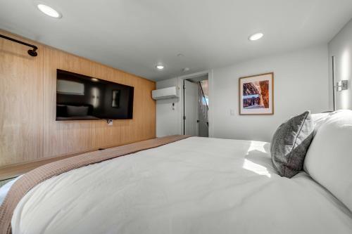 a bedroom with a large bed with a tv on the wall at The Riv at Zion in Virgin
