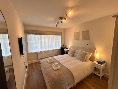 a bedroom with a large bed and a television at Room with private bathroom 5 min to Legoland & Windsor Castle - free parking and EV plug in Windsor