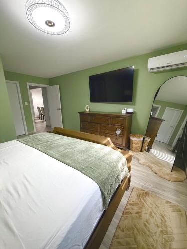 a bedroom with a bed and a flat screen tv at The Gatehouse Tobago in Buccoo