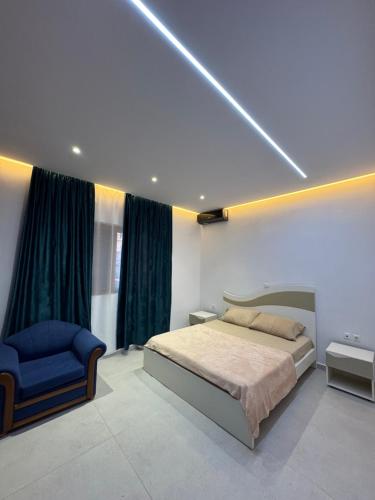 a bedroom with a bed and a blue chair at Azure Horizon in Çukë