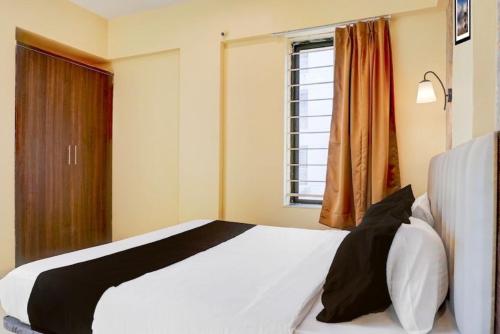 a bedroom with a white bed and a window at POP 84342C Hotel Jashoda in Jodhpur