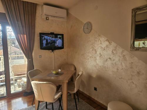 a dining room with a table and a tv on the wall at MakiLen in Vrnjačka Banja