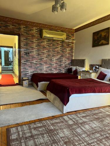 a bedroom with two beds and a brick wall at Nile Star Suites &Apartment in Cairo