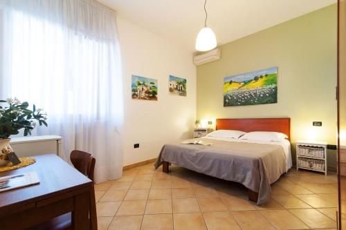 a bedroom with a bed and a table and a desk at Antico Camino B&B in Muro Leccese