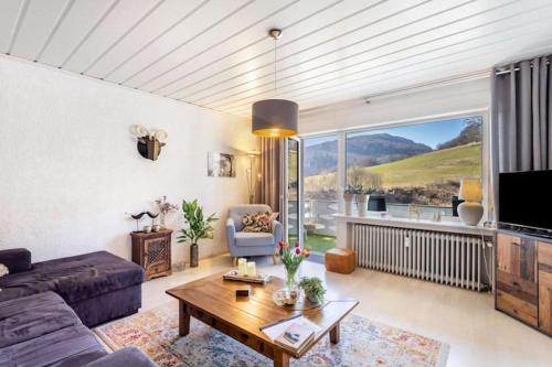 a living room with a couch and a table at Hirschblick Apartments Willingen in Brilon