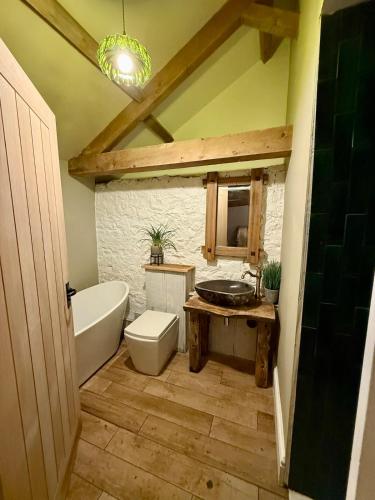 a bathroom with a tub and a toilet and a sink at The old stables at flass in Maulds Meaburn
