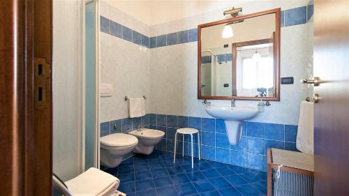 a bathroom with two toilets and a sink and a mirror at Antico Camino B&B in Muro Leccese