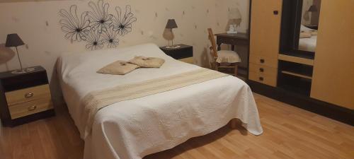 a bedroom with a bed with a hat on it at le moulin à vent in Céré-la-Ronde