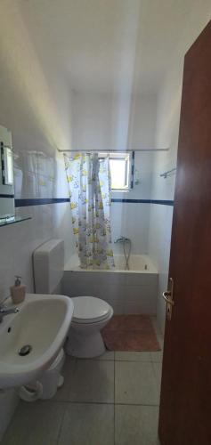 a bathroom with a toilet and a sink and a tub at Karouti-Rooms for Rent in Pteleos