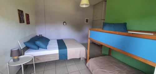 a small bedroom with a bed with blue pillows at Karouti-Rooms for Rent in Pteleos