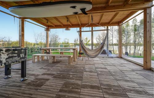 a large screened in porch with a hammock and a bench at Beautiful Home In Ostrowite With Lake View in Ostrowite